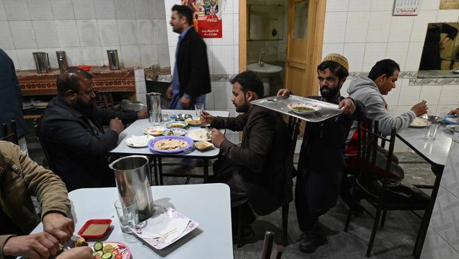 Rozi Khan, de 25 años, llevando comida a los clientes del Hotel Dilbar de Rawalpindi