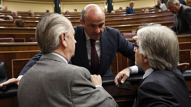 El ministro de Economía charla con otros diputados durante la sesión de control