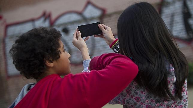 Dos niños jugando con un «smartphone»