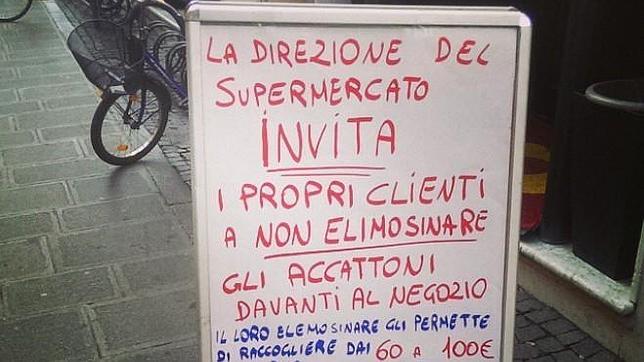 Cartel en el que se insta a no dar limosna a los mendigos en un supermercado de Ferrara