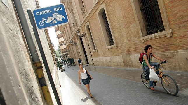 Una viandante y una ciclista transita por una zona de carril bici de Valencia