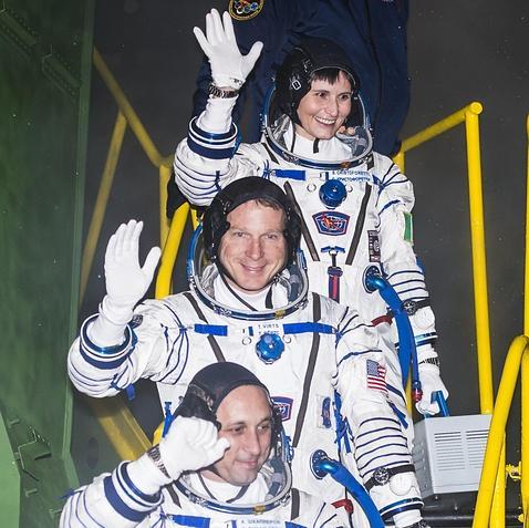 Samantha Cristoforetti y sus compañeros Terry Virts y Anton Shkaplerov saludan antes de subir a la nave Soyuz