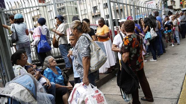 Venezolanos hacen cola para entrar en un supermercado de Caracas