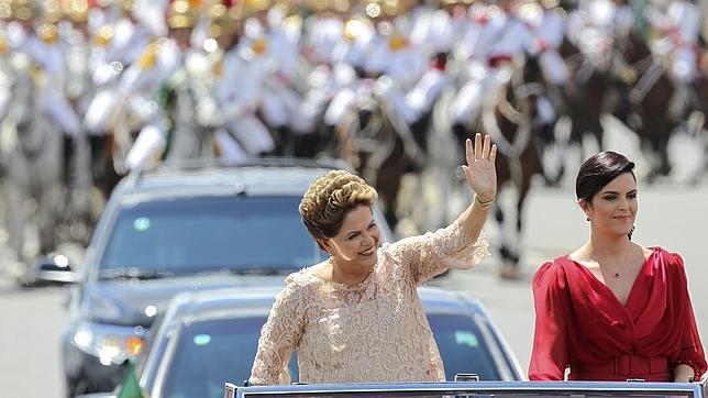 Rousseff, junto a su hija, Paula, saluda a bordo de un Rolls Royce