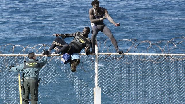Dos inmigrantes intentan saltar la valla de Ceuta. Archivo