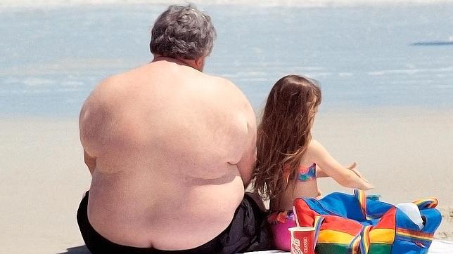 Un hombre junto a su hija en una playa