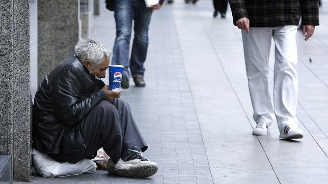 Un mendigo en el suelo de la gran vía madrileña