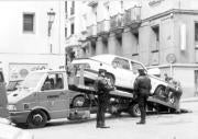 Dos policías supervisan una de las múltiples actuaciones de la grúa municipal en una céntrica calle. ABC
