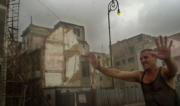 Un operario intenta evitar el paso de la gente hacia una zona con construcciones inseguras en la Habana Vieja, tras las intensas lluvias caídas. Ap