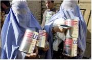 Mujeres afganas portaban hoy bidones de aceite para cocinar proporcionados por la ayuda norteamericana. Foto: Epa