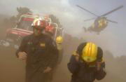 AFP Los bomberos se protegen del polvo que levanta un helicóptero en Casavieja (Ávila)