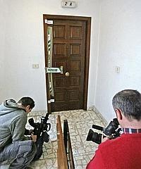 Dos reporteros de televisión graban la puerta del domicilio donde esta madrugada una joven boliviana fue estrangulada por su novio, lo que eleva a tres el numero de fallecidas a manos de sus compañeros o maridos en Galicia en lo que va de año, todos ellos en el presente mes de febrero. / EFE