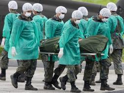 Militares descargan del helicóptero H-60 BlackHawk de la Fuerza Aérea brasileña los primeros ocho cadáveres de las víctimas del accidente del avión Airbus A330-200 de Air France. / Efe
