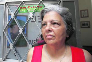 REUTERS Martha Beatriz Roque, de origen canario, observa una fotografía de Castro reflejada en la puerta de su casa de La Habana, en 2006