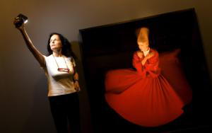 Isabel Muñoz, ayer en la Sala Canal, junto a una de sus fotografías de derviches danzando en éxtasis I FOTO IGNACIO GIL