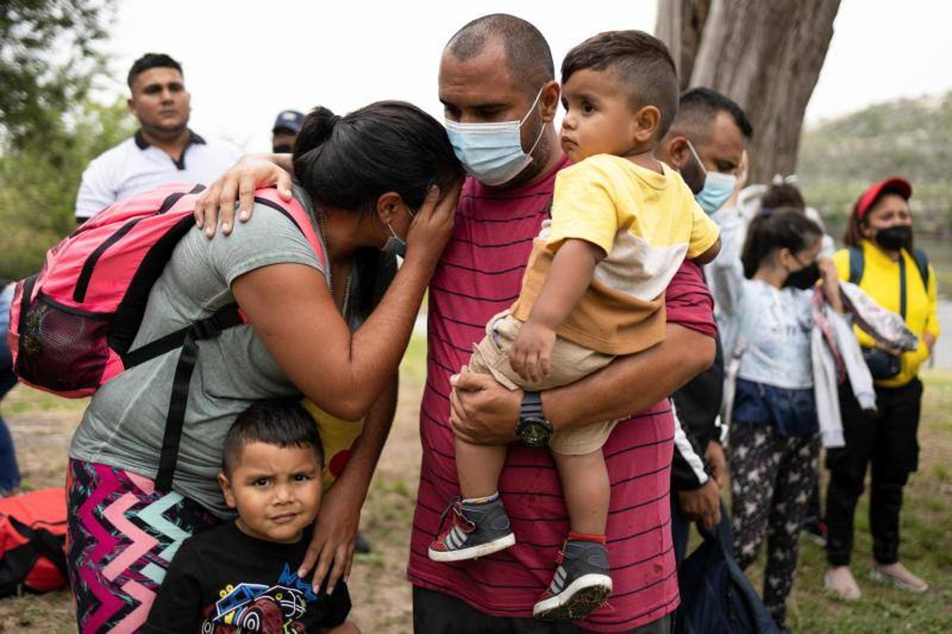 Una familia de inmigrantes espera a ser trasladada a una instalación de procesamiento de la patrulla fronteriza de EE. UU.