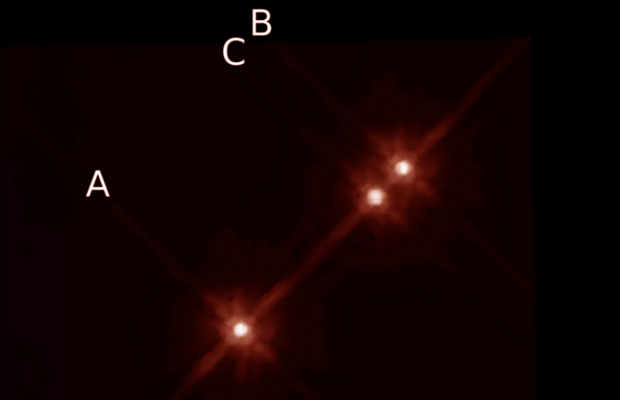 En la imegen de Telescopio Espacial Hubble se aprecian las tres estrellas de este sistema triple. El planeta fue descubierto en órbita de la estrella A.