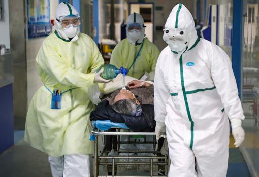 Trabajadores sanitarios chinos atienden a un enfermo de COVID-19