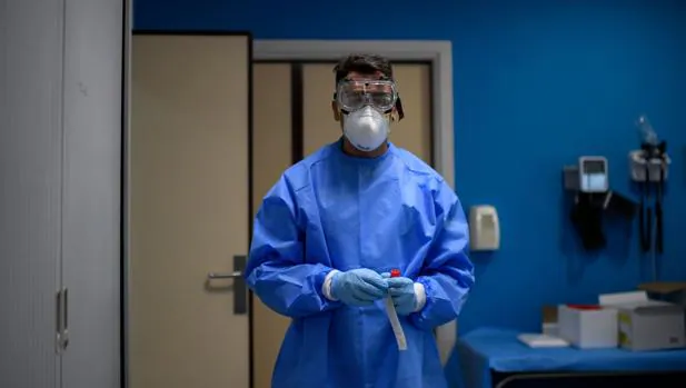 Un trabajador sostiene una muestra en un centro donde se realizan pruebas para detectar el coronavirus, en Madrid, este lunes