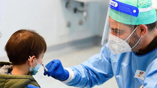 Un médico militar administra una vacuna para la gripe a un niño, este viernes, en Milán, Italia