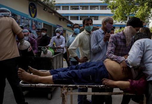 Family members cry after a man dies outside the coronavirus disease victim ward at Guru Teg Bahadur Hospital in New Delhi