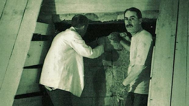 Lord Carnavon se asoma al interior de la cámara mortuoria de Tutankamón, junto a Howard Carter que mira a la cámara