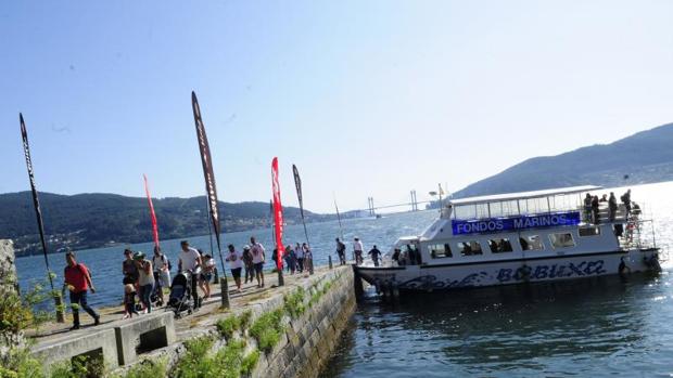 Los visitantes desembarcan del ferry en la isla de San Simón