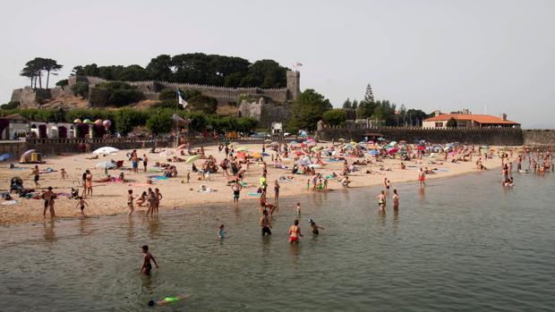 Turistas y vecinos se refrescan en la playa de Riveira en Baiona