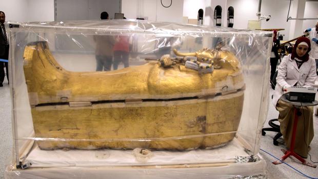 Una arqueóloga egipcia trabaja junto al sarcófago dorado del faraón Tutankamón
