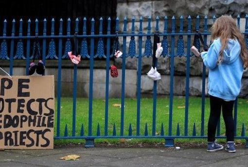 Zapatos de niños colgados a la entrada de la Catedral de DublÃn como protesta simbólica contra la pederastia