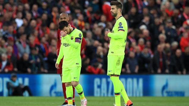 Messi y Piqué se lamentan durante el partido en Anfield