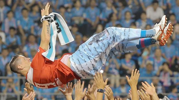 Torres, manteado en por sus compañeros del Sagan Tosu tras el partido
