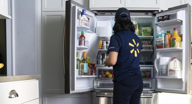 Una empleada de Walmart coloca un pedido dentro del frigorífico
