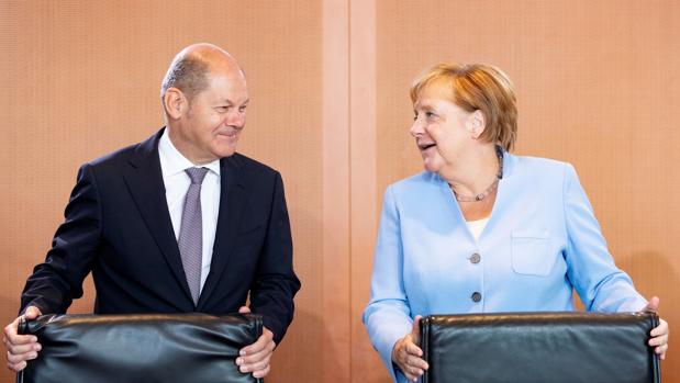 El ministro de Finanzas alemán, el socialdemócrata Olaf Scholz (izda) junto a la canciller alemana, Angela Merkel (dcha)