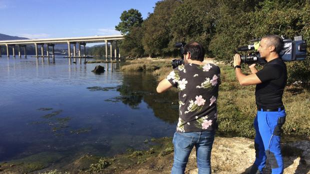 Dos reporteros fotografían la zona de Taragoña donde apareció el móvil de Diana Quer
