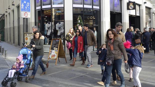 Varias personas pasean delante de la tienda del Real Madrid en Gran Vía, ayer por la mañana