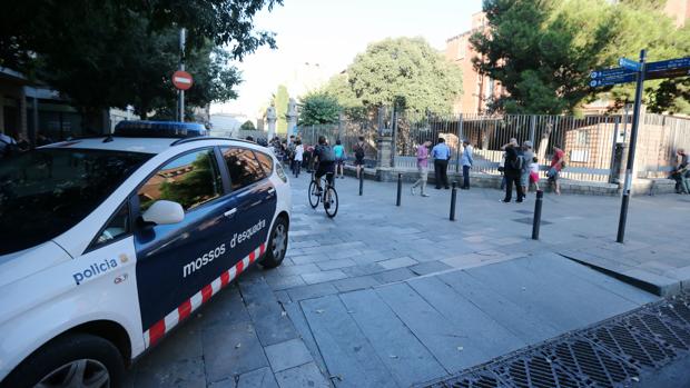 Un coche e los Mossos, aparcado frente a la escuela Collaso i Gil, en el Raval de Barcelona