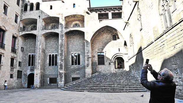 Un turista fotografía la plaza del Rei en Barcelona