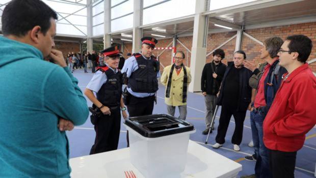 Varios Mossos esperan al recuento de votos para retirar las urnas durante el 1-O