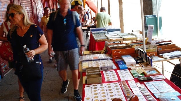 Un grupo de turistas pasea junto a uno de los puestos, en la plaza Mayor