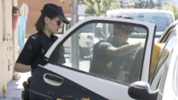 Momento en que dos agentes introducen al acusado en un coche patrulla para trasladarle a prisión