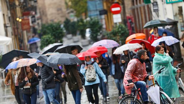 Un grupo de personas se protege de la lluvia en Valencia en una imagen de archivo