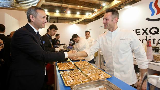 César Sánchez saluda a un cocinero en la feria de turismo de Madrid