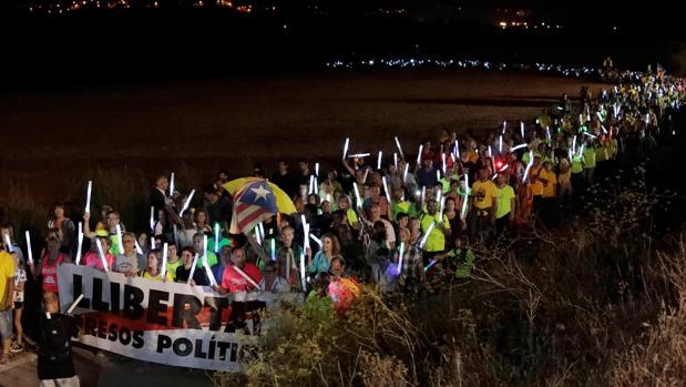 Varios manifestantes marchan con antorchas durante una movilización independentista convocada por la ANC