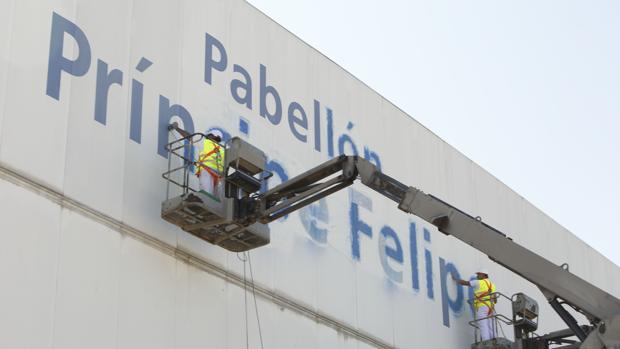 Operarios borrando el nombre del pabellón por orden del gobierno municipal, hace cuatro años