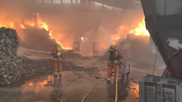 Efectivos de bomberos trabajan en la extinción del incendio en la plata de reciclaje