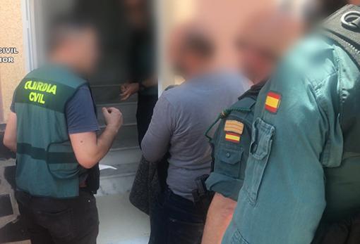 Uno de los detenidos custodiado por la Guardia Civil