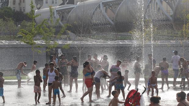 Un grupo de gente se refresa en las fuentes de Madrid Río por la ola de calor