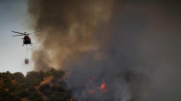 Un helicóptero de bomberos trabaja en la extinción del incendio