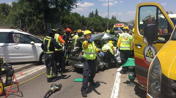 Bomberos y sanitarios atendiendo a los heridos en el lugar del accidente